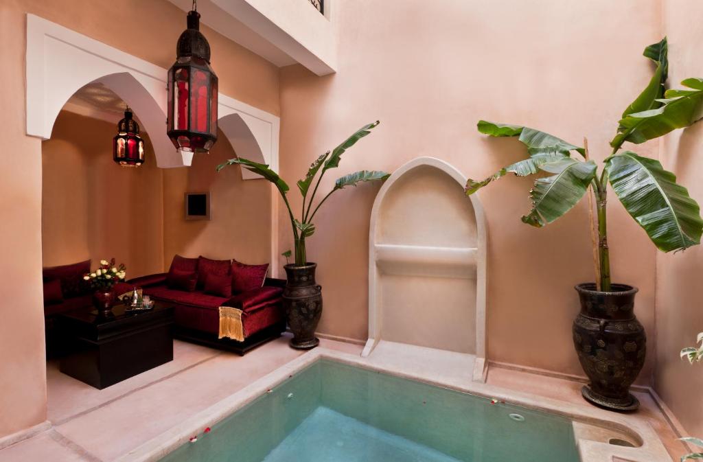 马拉喀什里亚德乐红宝石酒店的一间带植物浴缸和沙发的房间