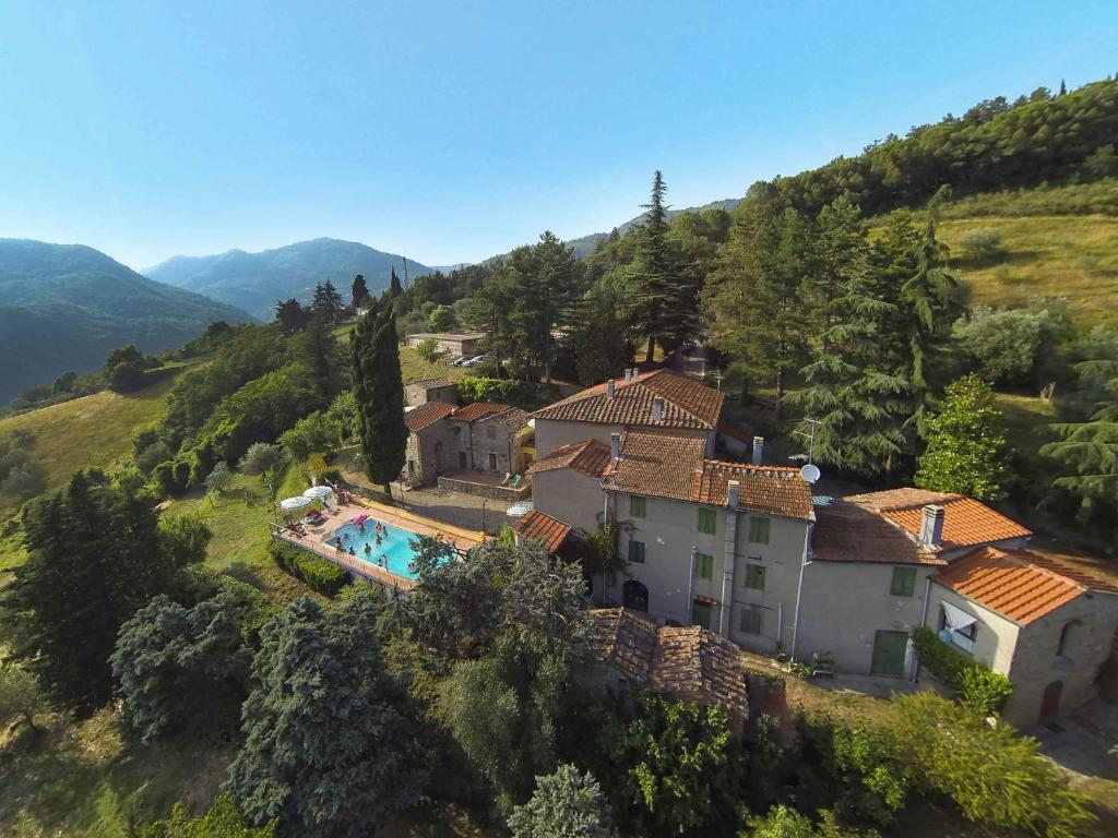 VernioAgriturismo Corboli的享有山丘上房屋的空中景致,设有游泳池