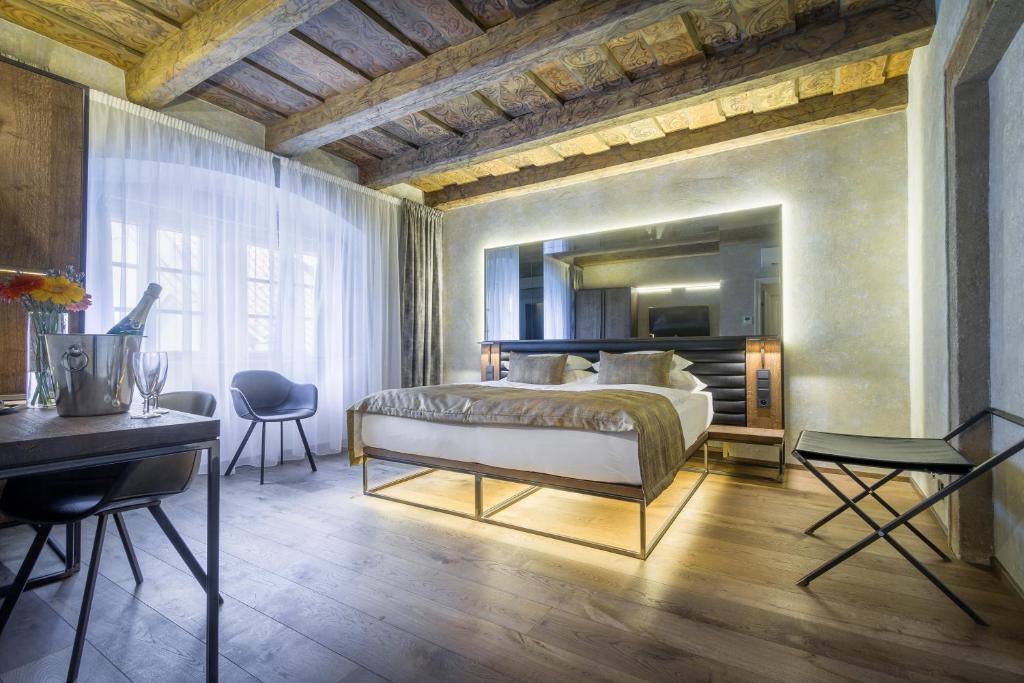 布拉格瓦尔德施泰因酒店的一间卧室配有一张床、一张桌子和一张书桌