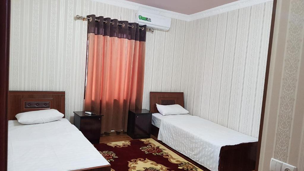 撒马尔罕B&B Giza Registan的一间设有两张床和红色窗帘的房间