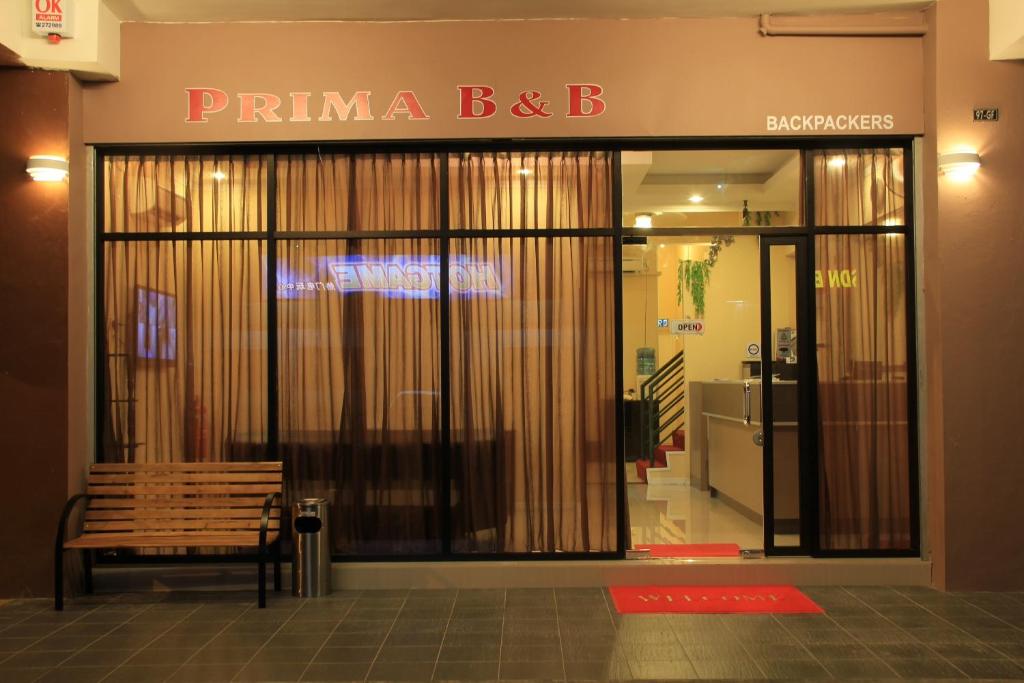 山打根Prima B&B Hostel的大楼前方的商店,有长凳