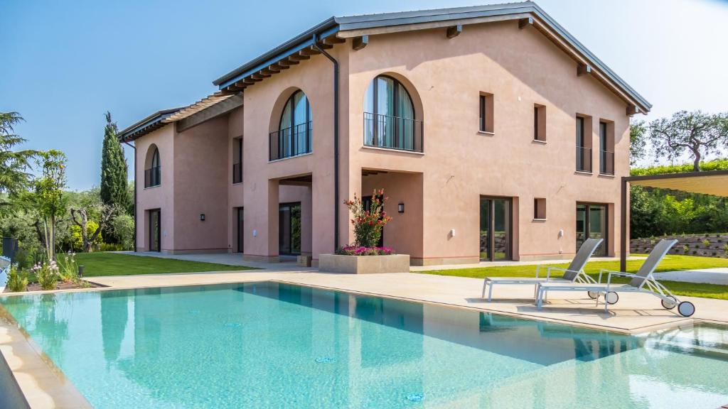 拉齐塞Villa Collivo的房屋前有游泳池的房子