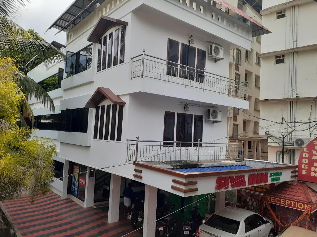 古鲁瓦尤尔Shiva Inn的街道上带阳台的白色建筑