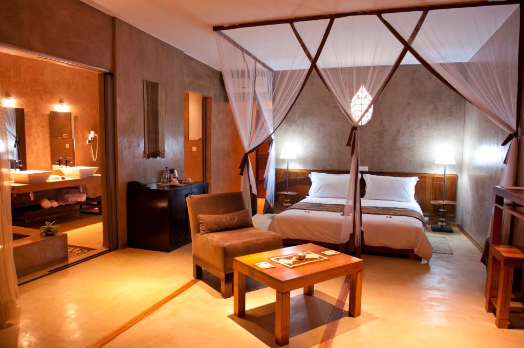 RanohiraIsalo Rock Lodge的一间卧室配有一张床、一把椅子和一张桌子