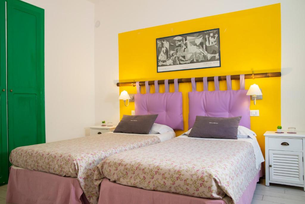 特伦托莫瓦西亚住宿加早餐旅馆的黄色和粉红色客房的两张床