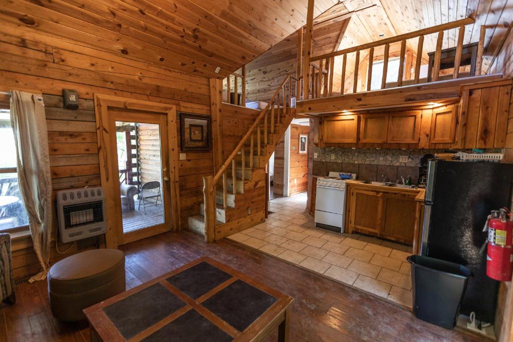 丘巴Meramec River Resort的小屋内的厨房设有木墙和楼梯