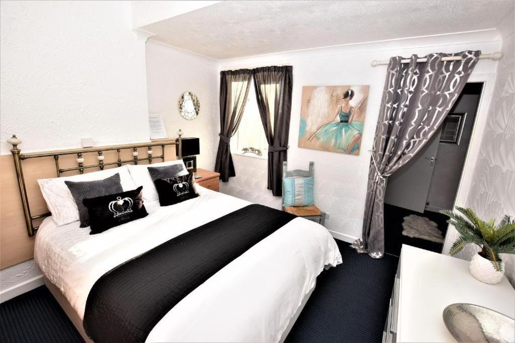 布莱克浦Bridle Lodge Apartments的一间卧室配有一张大床,提供黑白枕头