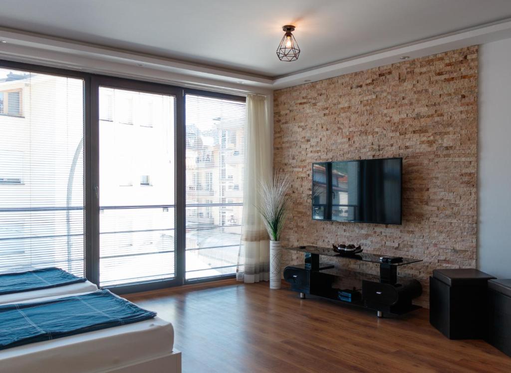 奥赫里德Ana's Apartments的一间带砖墙和电视的卧室