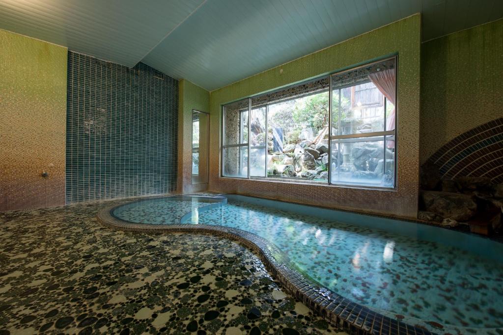 松本马路纳卡酒店的窗户客房内的大型游泳池