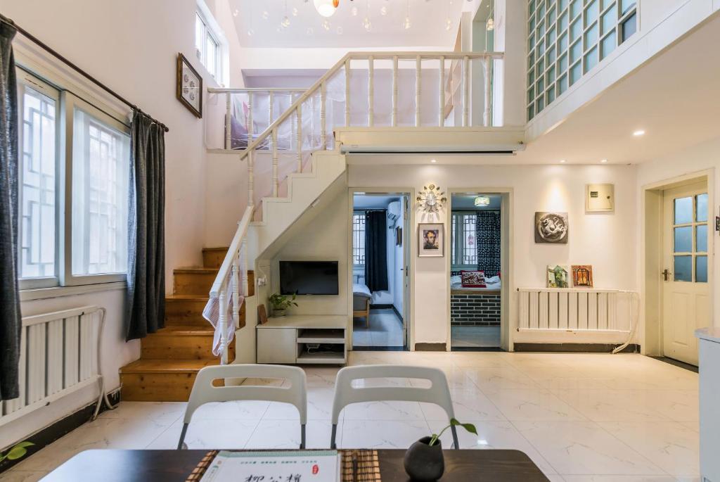 西安西安古城墙下您舒适的家的一间带楼梯和白色椅子的客厅