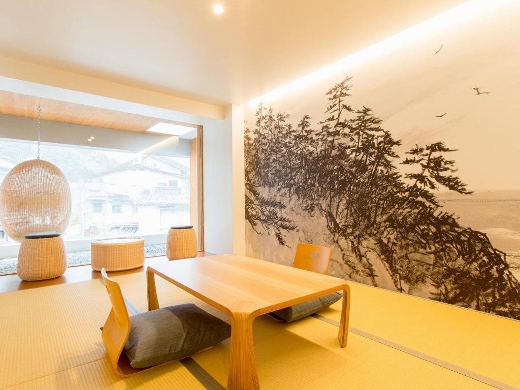 丰冈市UTSUROI Tsuchiya Annex的客厅设有桌子和大窗户