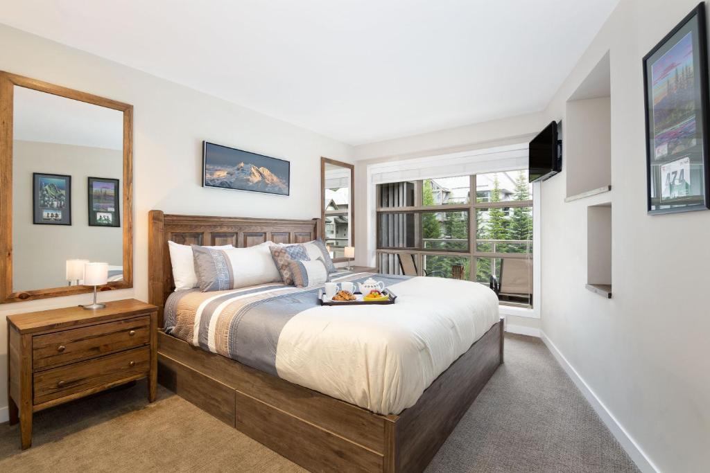 惠斯勒Aspens Mountain Side Resort的一间卧室设有一张大床和一个窗户。