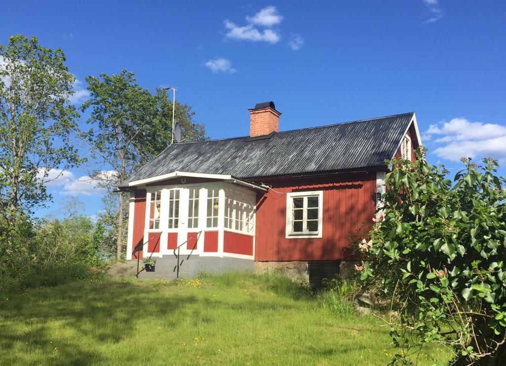KristdalaMalghults Gård的一块田野上黑色屋顶的红色房子