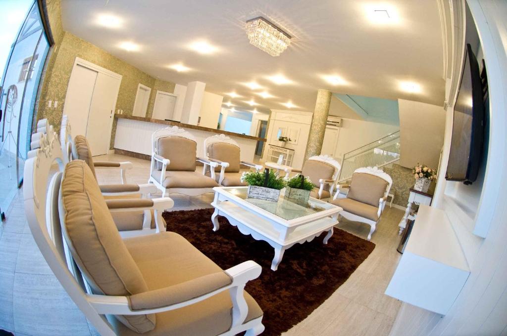Forquilhinha奥玛兹塔酒店的一间设有椅子和桌子的房间和一间白色的房间