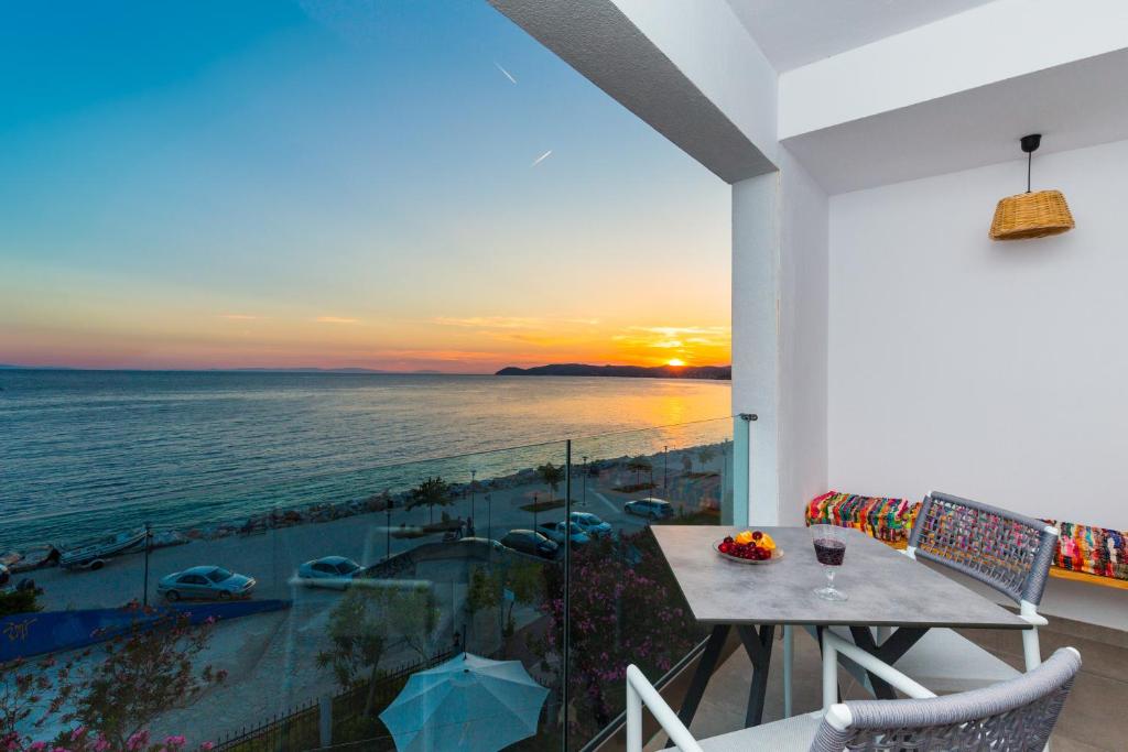 波托什Pension Ageri的阳台配有桌子,享有海景。