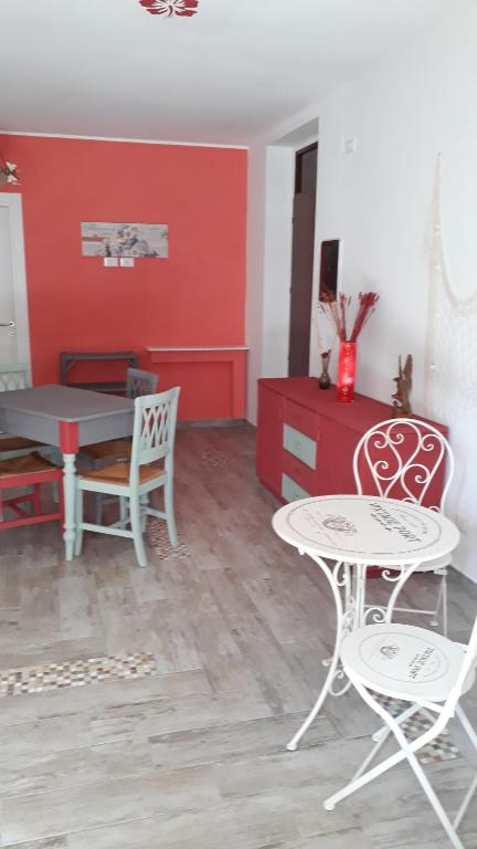 丰迪La rezztella的客厅配有桌椅和红色墙壁