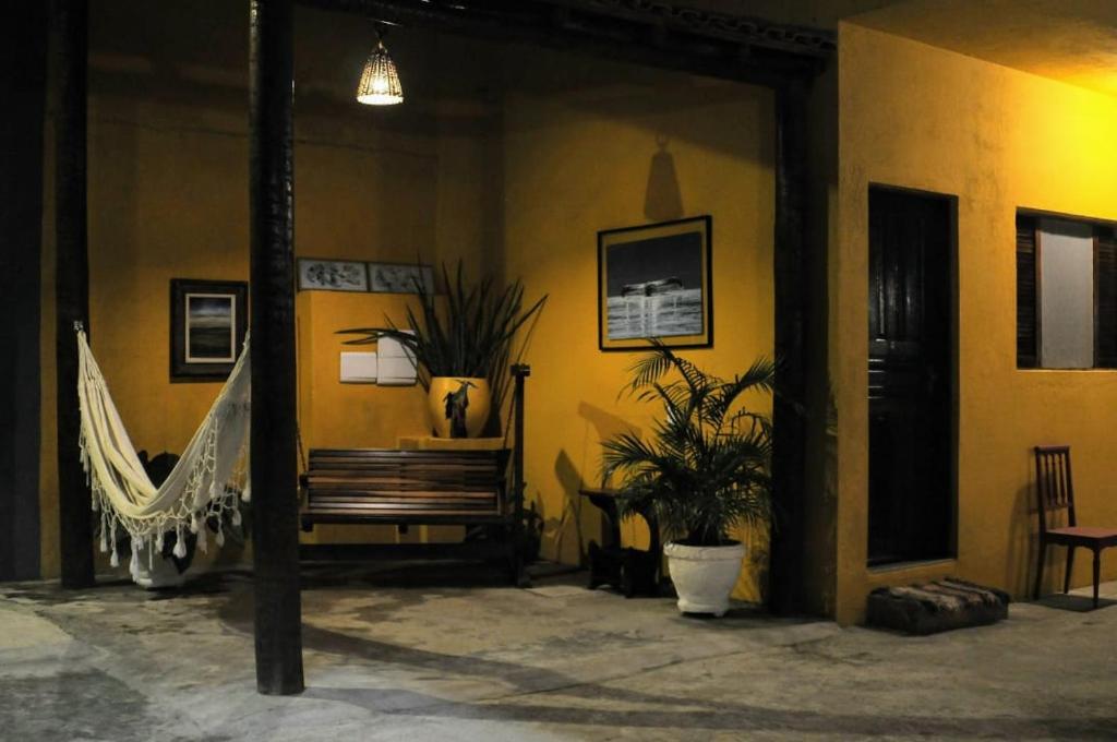 佩鲁伊比Guaraú Praia Suítes的一间带长凳和吊床的房间