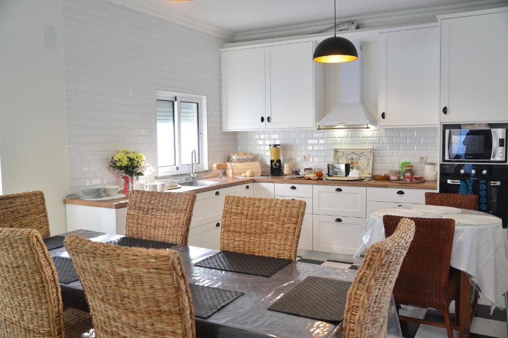 戈韦阿Blue Castle House的一间带桌椅的厨房和一间带白色橱柜的厨房