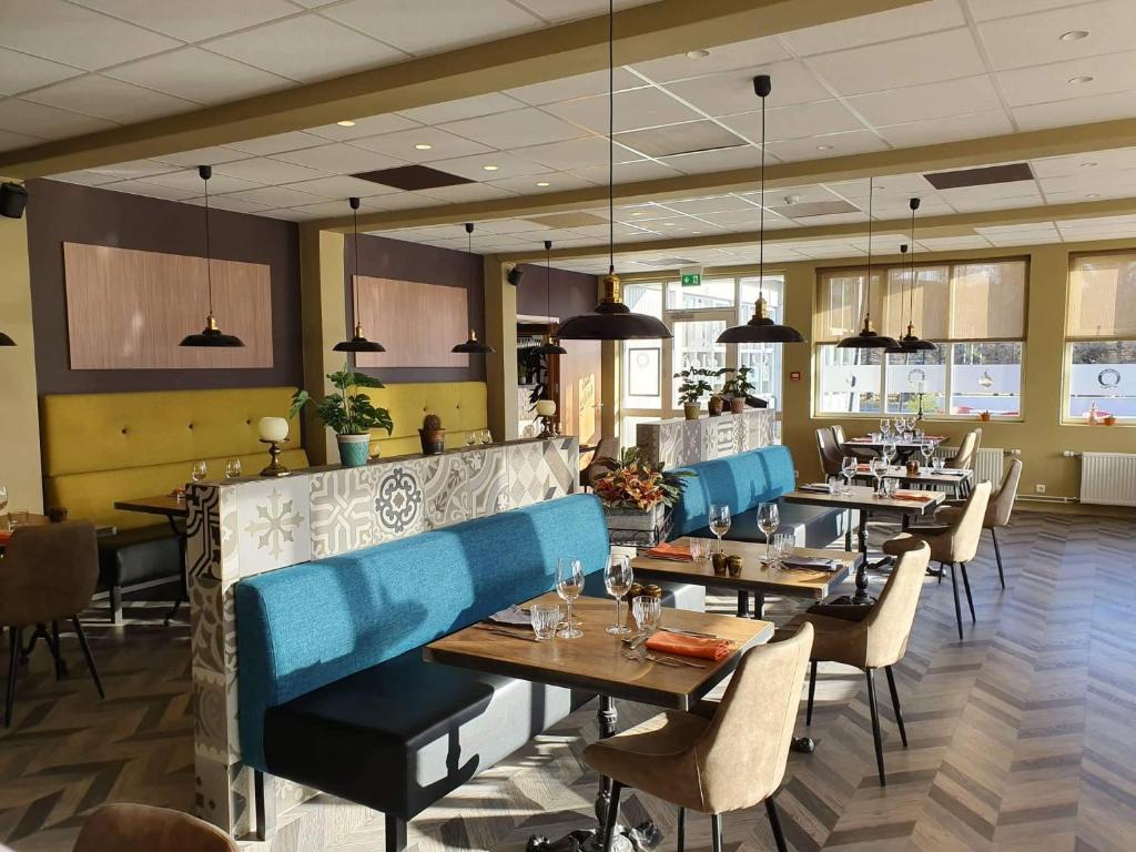 埃基斯蒂尔瓦拉斯卡尔夫酒店的餐厅设有木桌和蓝色椅子