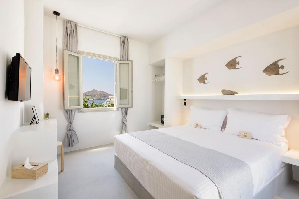 纳乌萨Peven Suites的白色的卧室设有床和窗户