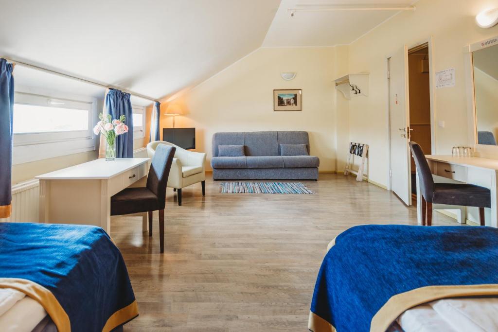 塔林经济酒店的客房设有两张床、一张桌子和一张沙发。