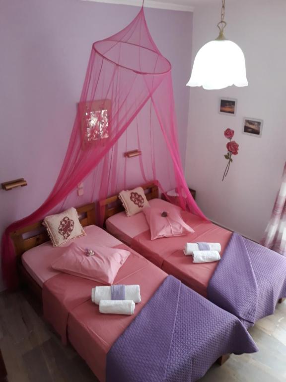 阿齐欧斯·贡多斯索菲亚玛格丽塔旅馆的配有粉红色和紫色床单的客房内的两张床