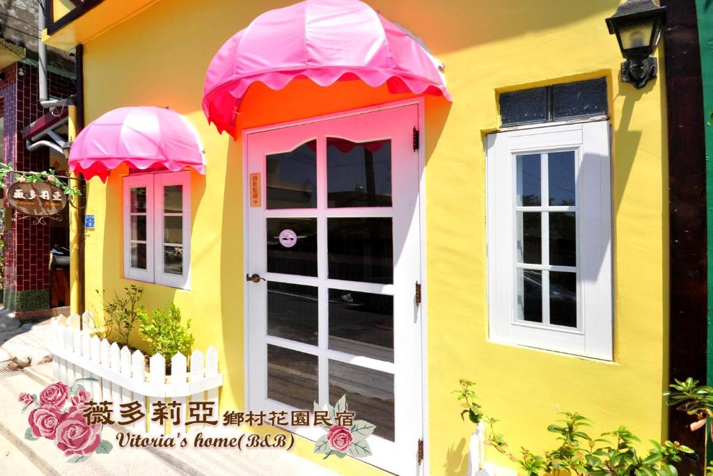小琉球岛薇多莉亚乡村花园民宿的粉红色的黄色房子