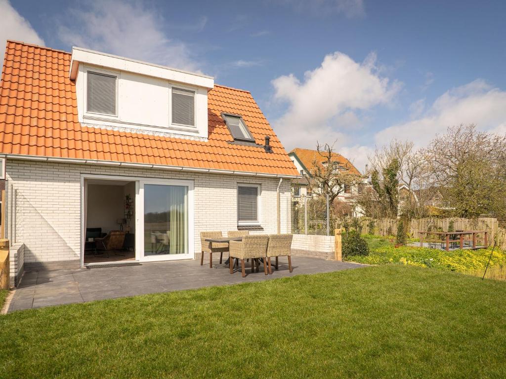 德科克斯多普fantastic bungalow on Texel的房屋设有带桌椅的庭院