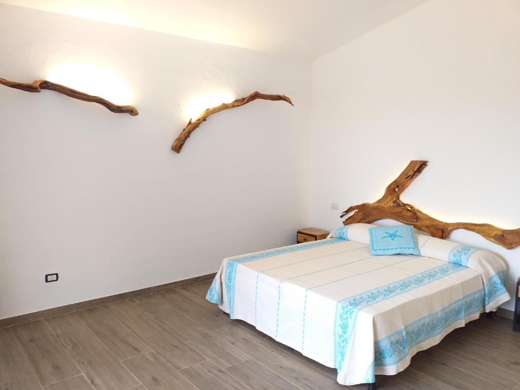 阿尔扎凯纳Turismo Rurale Lu Stazzu Arzachena的卧室配有一张床铺,墙上有树枝