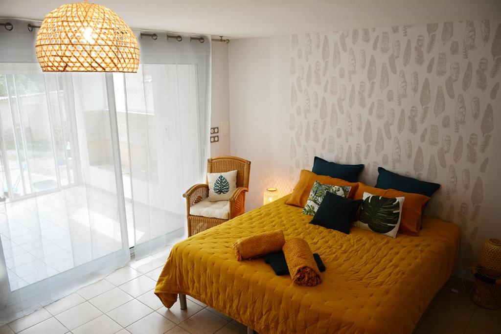 罗纳河畔的图尔农L'Oiseau Bleu的一间卧室设有一张黄色的床和大窗户
