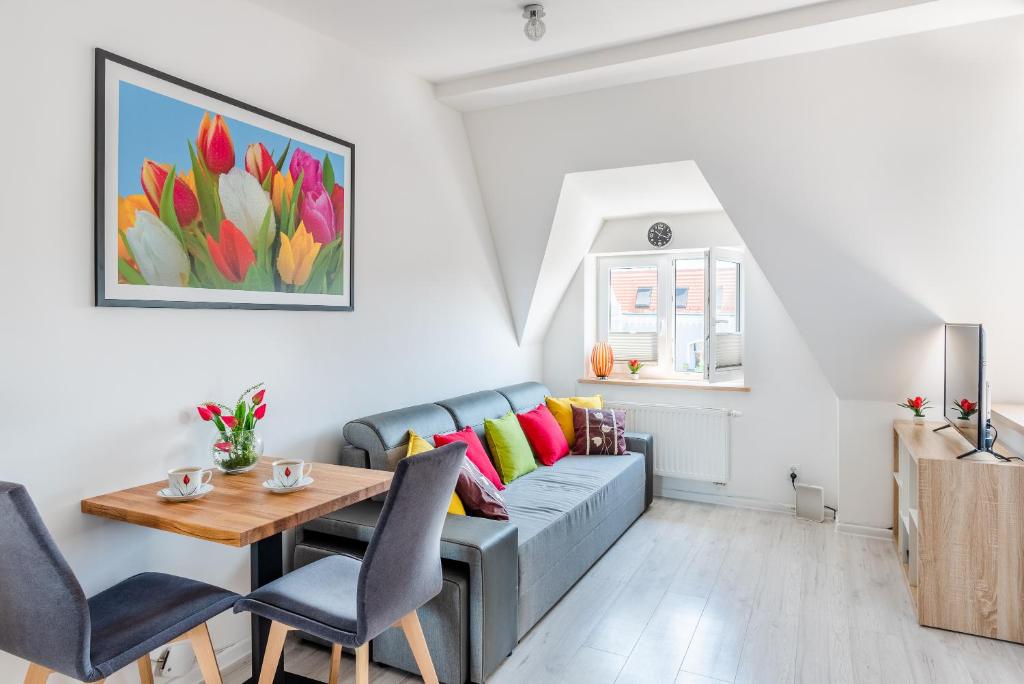 什切青Tulip-Apartments - Jagiellońska 24 poddasze bez windy的客厅配有沙发和桌子