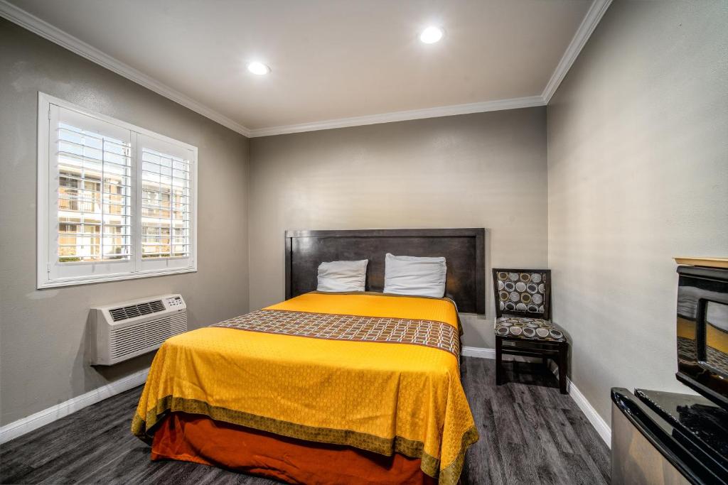 唐尼唐尼丽晶汽车旅馆的一间卧室配有一张黄色毯子床