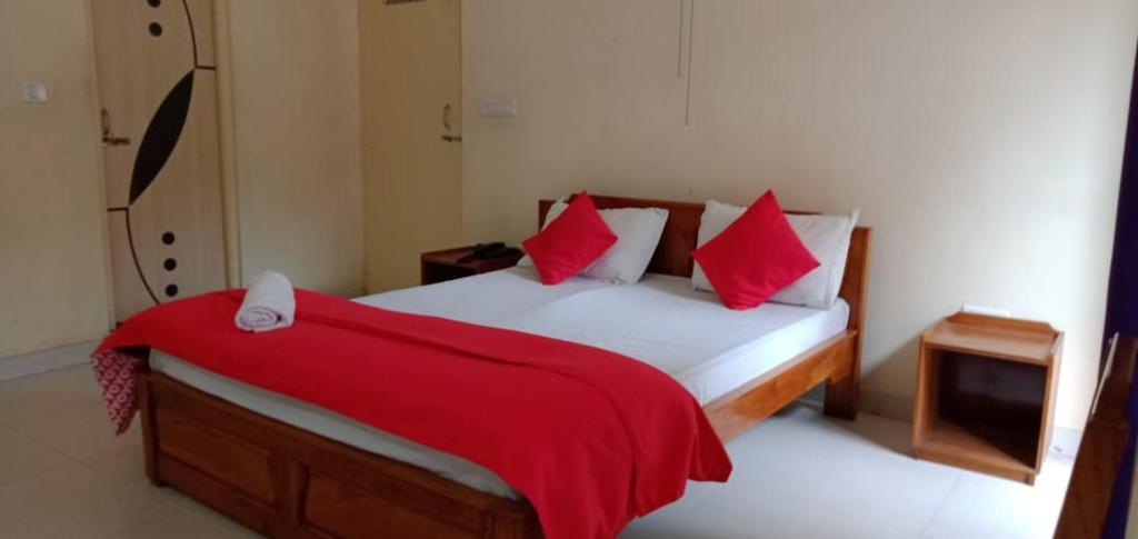 噶伦堡Pokhrel Lodge的一间卧室配有一张床铺,床上铺有红色毯子