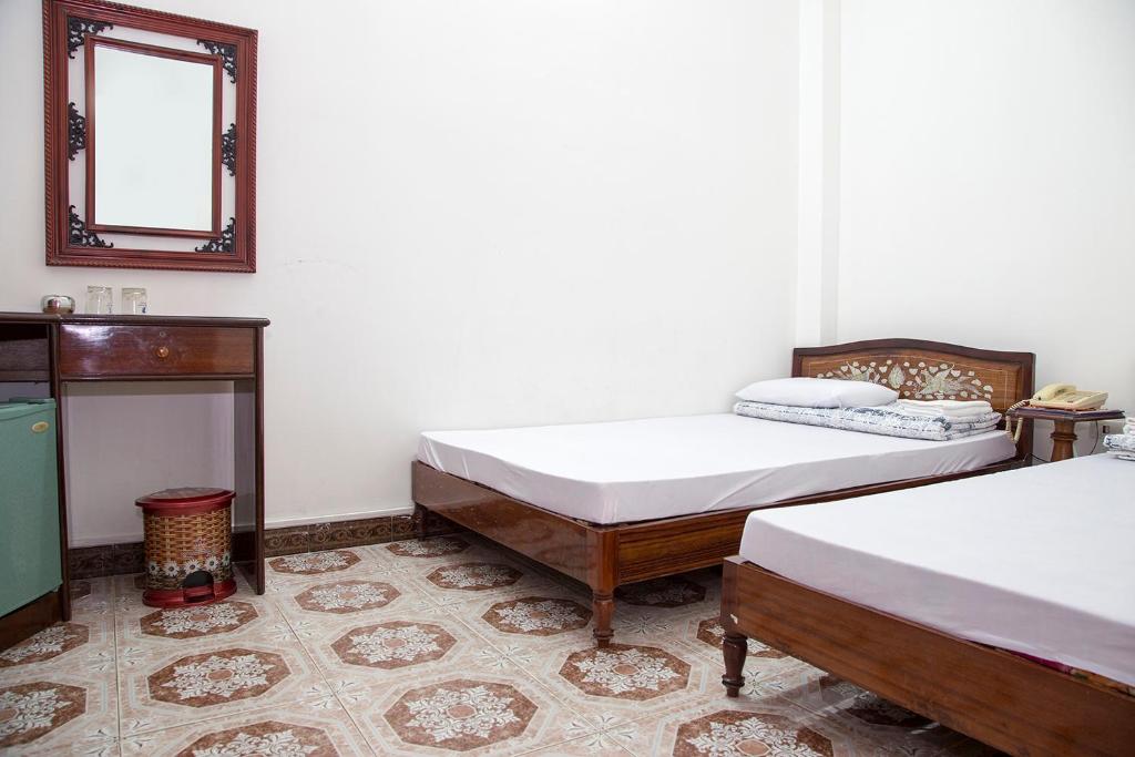 金瓯宋红酒店的一间设有两张床的客房和墙上的镜子