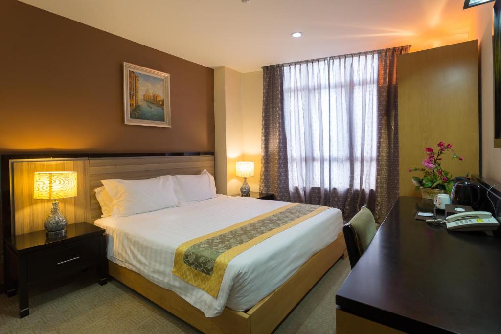 马六甲豪门大酒店的酒店客房设有一张大床和一张书桌。
