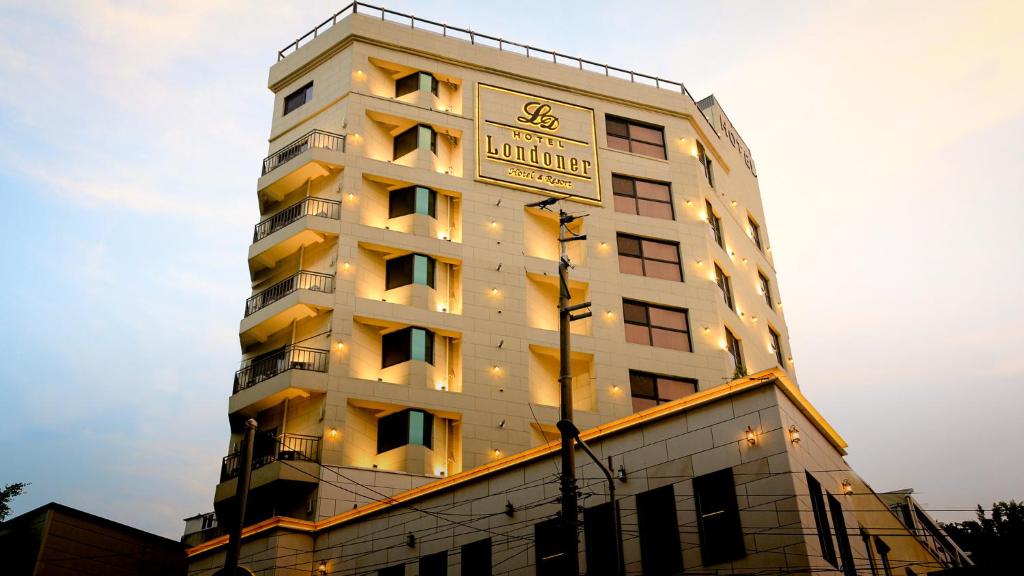 釜山Londoner Hotel Gwangan的一座高大的白色建筑,上面有时钟