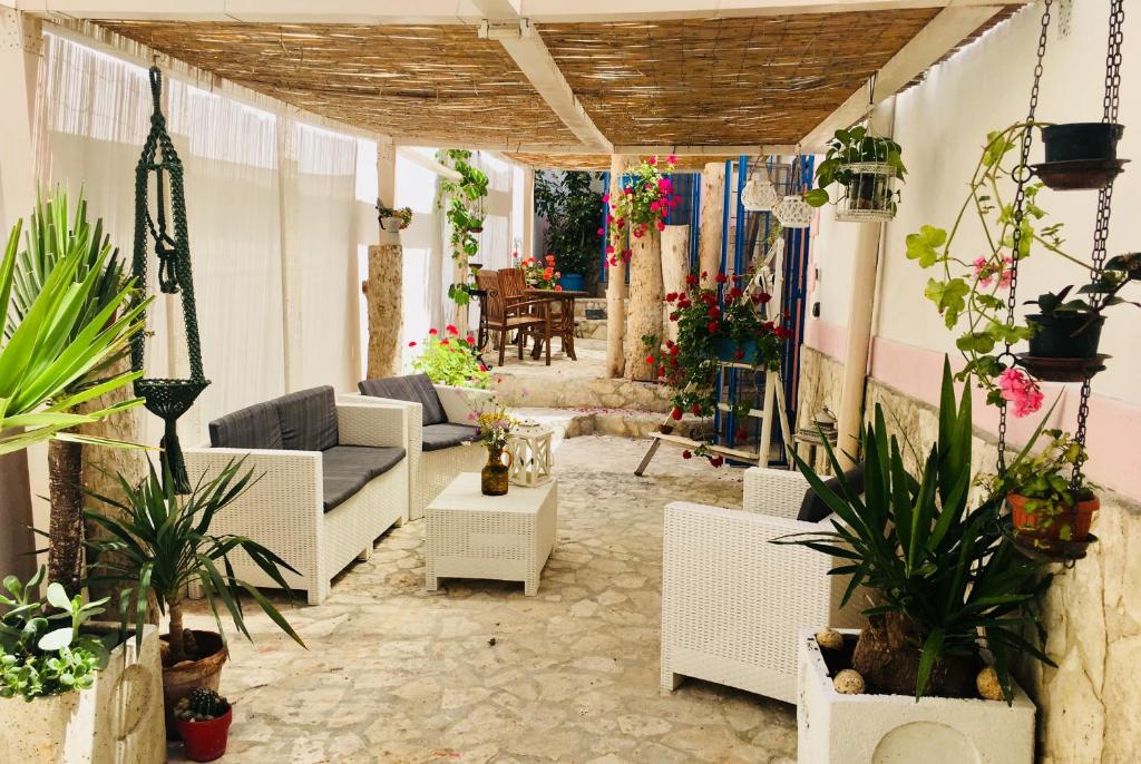 维耶斯泰Il Giardino dei Limoni的庭院配有白色家具和盆栽植物