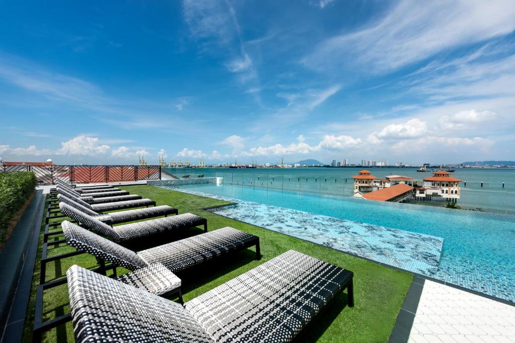 乔治市The Prestige Hotel Penang的一个带躺椅和水的游泳池