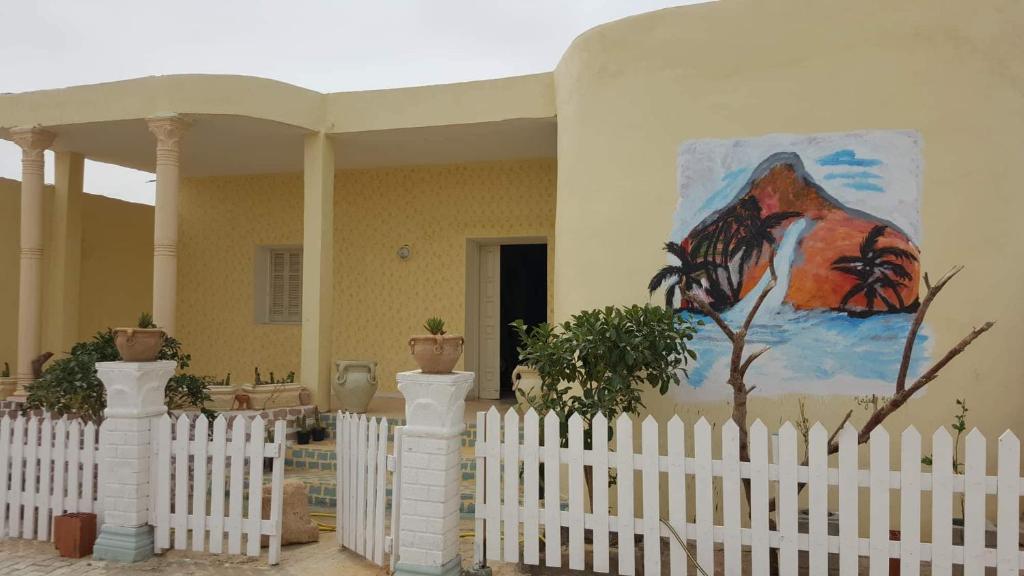 ShabīkahVilla Atlas Oasis的房屋前的白色栅栏,上面有绘画