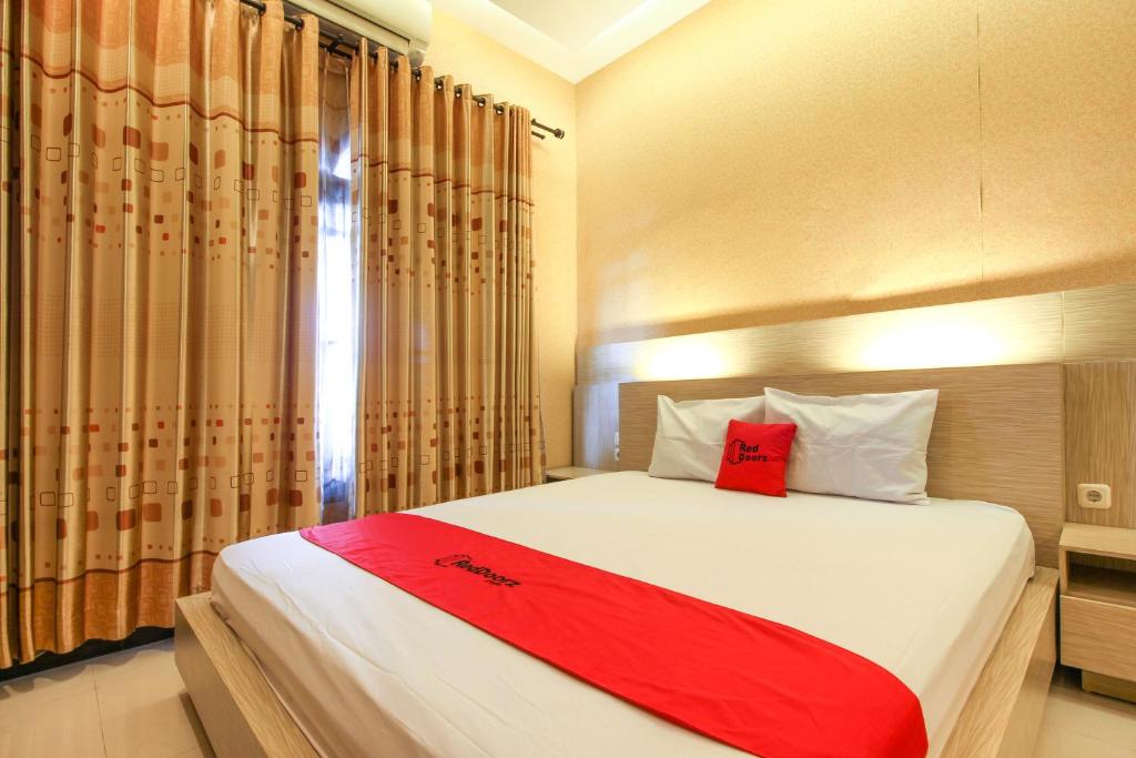日惹RedDoorz near Candi Ratu Boko的一间卧室配有一张床铺,床上铺有红色毯子