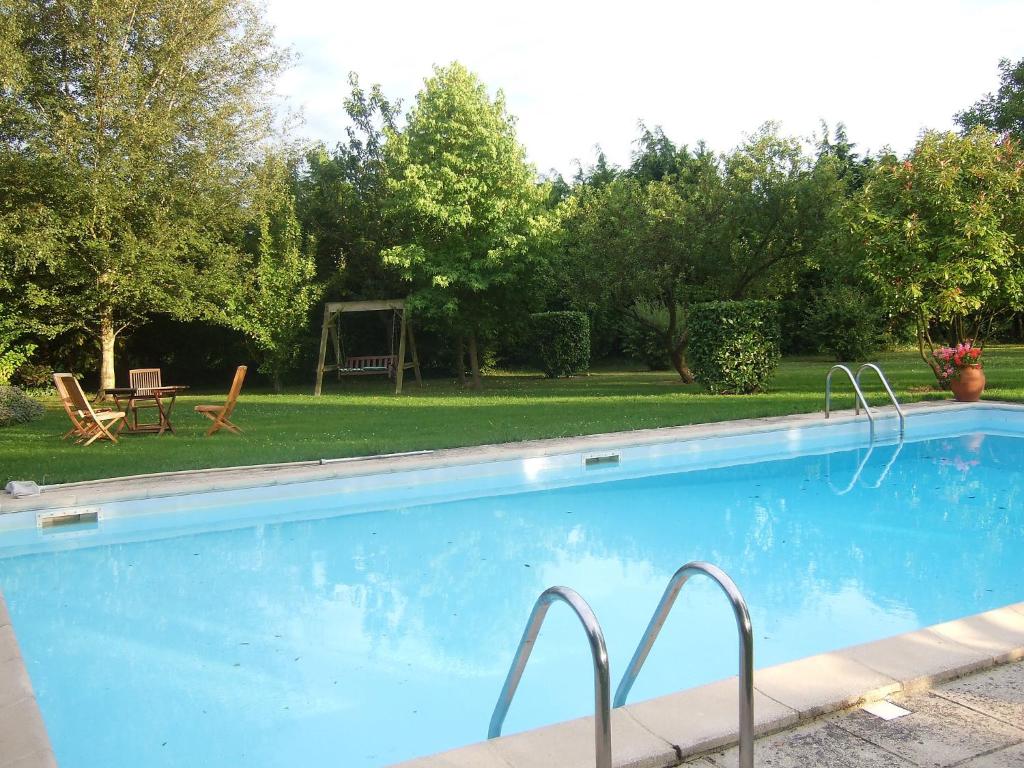 Crouay莱斯隆德游恩贝辛度假屋的庭院内的游泳池,配有桌椅