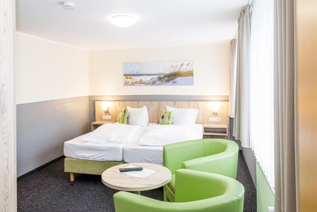 库克斯港Gästehaus Alexandra的酒店客房带一张床、一张桌子和椅子