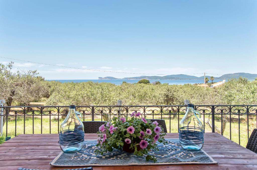 阿尔盖罗Brassol Casa Vacanze Vista Mare的木桌,带两杯酒杯和插花