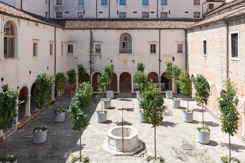 威尼斯Combo Venezia的庭院里种有盆栽树木,设有喷泉