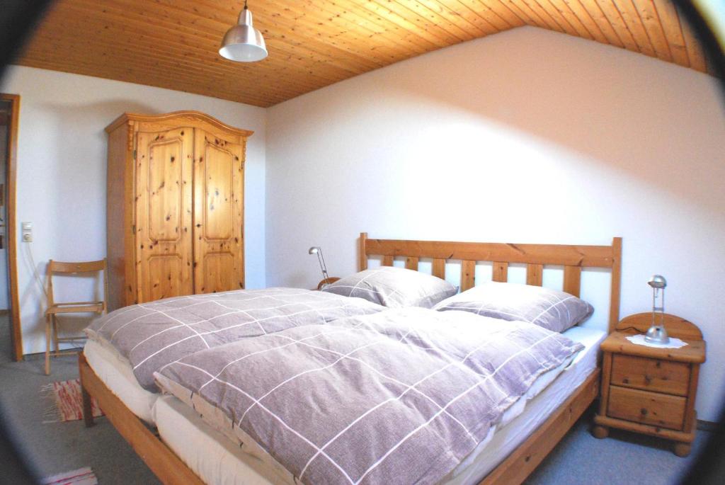 阿尔戈伊地区伊斯尼Ferienwohnung Hilmes-Walravens的一间卧室设有一张大床和木制天花板