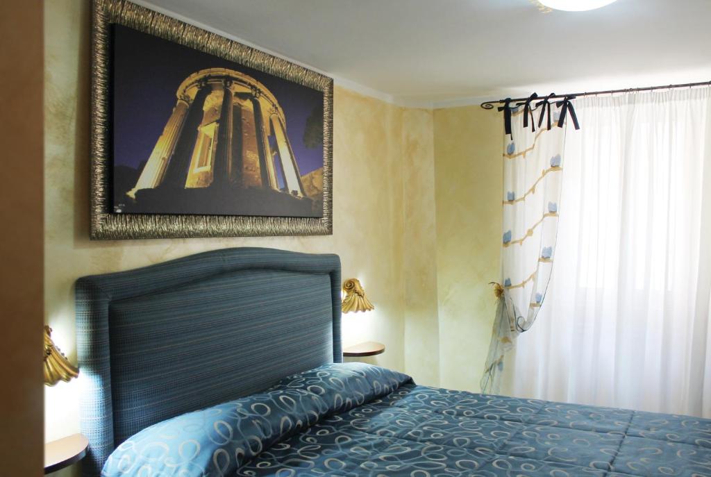 蒂沃利吉亚达旅馆的卧室配有一张床,墙上挂着一幅画