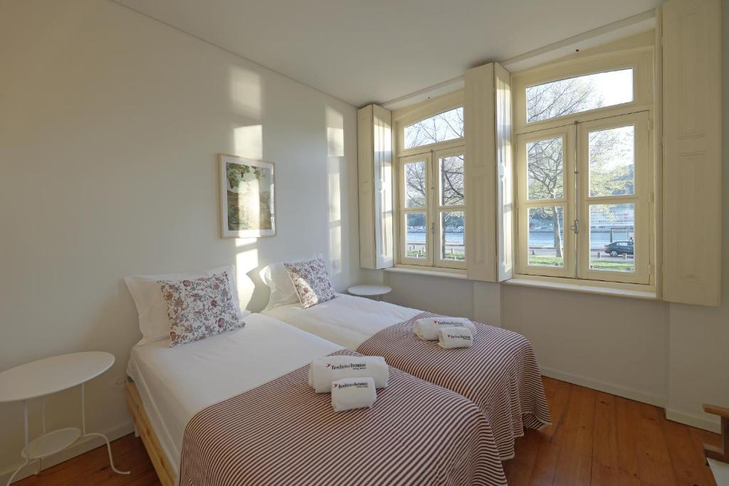 波尔图FLH Oporto Captain House的一间卧室设有两张床和两个窗户。