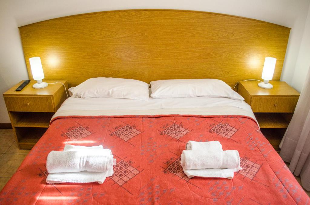 门多萨格兰纳德罗斯考姆普利耶公寓的一间卧室配有一张大床和毛巾