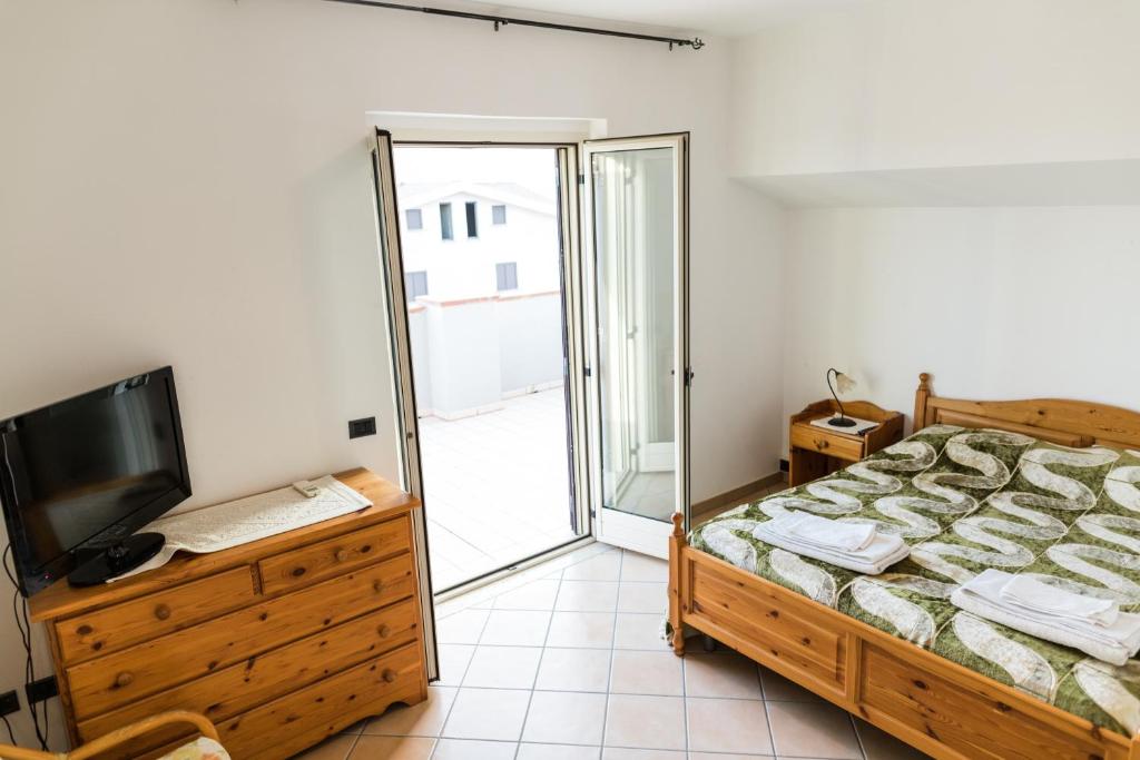 索威拉托玛里纳托雷昂契纳勒酒店的一间卧室设有一张床、一台电视和一个阳台。
