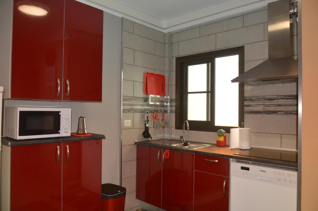 戈梅拉岛圣塞瓦斯蒂安Calle Real的一间带红色橱柜和微波炉的厨房